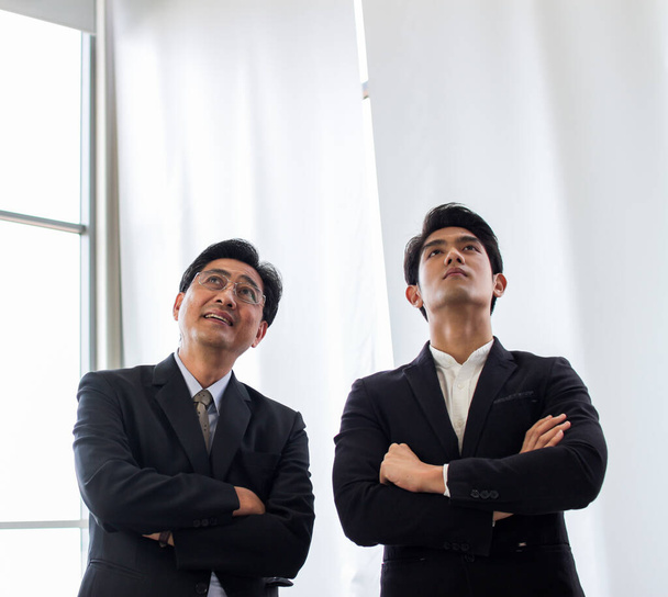 група азіатських успішних бізнесменів, що стоять на перехресній руці. Різноманітна бізнес команда посміхається, дивлячись в офіс
 - Фото, зображення