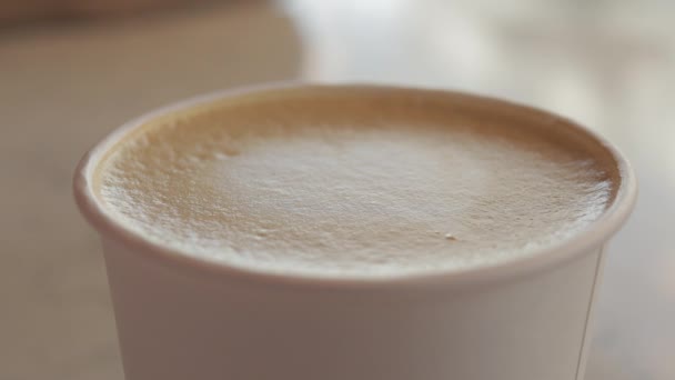 capuchino café o blanco plano con espuma de leche en taza de papel desechable. - Metraje, vídeo