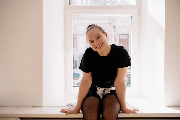 Aranyos tinédzser portré ül az ablak mellett - Fotó, kép