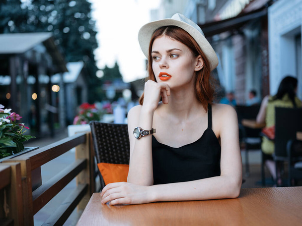 Mooie vrouw in straat cafe model restaurant emoties hoed jurk - Foto, afbeelding