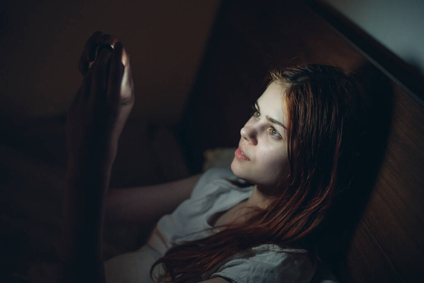 γυναίκα με τηλέφωνο στο χέρι κρεβάτι εθισμού υπόλοιπο τεχνολογία - Φωτογραφία, εικόνα