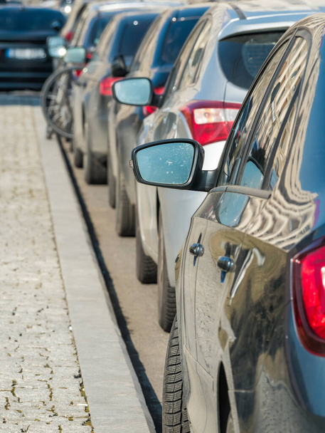 Wyrównane równoległe zaparkowane samochody na poboczu ulicy lub drogi. - Zdjęcie, obraz