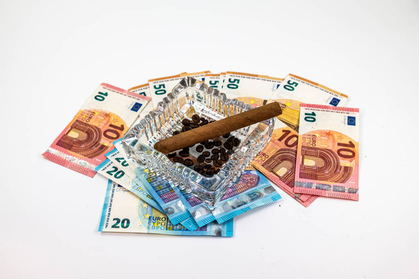 50 банкнот 20 10 евро с пепельницей и сигарой на белом фоне - Фото, изображение