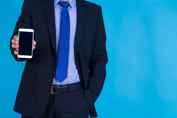 businessman with mobile phone on blue background - Zdjęcie, obraz