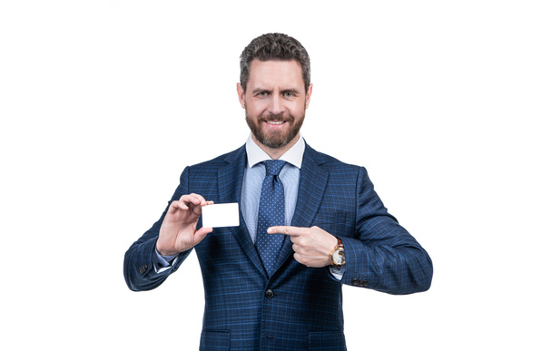 succesvolle zakenman in zakelijk pak wijzend vinger op lege debet of visitekaartje voor kopieerruimte geïsoleerd op wit, contact met mij op. - Foto, afbeelding