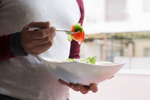 man eating salad bowl with tomato and lettuce, diet and food concept - Foto, Imagem