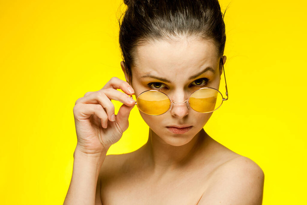 woman naked shoulders yellow glasses gathered hair - Photo, Image