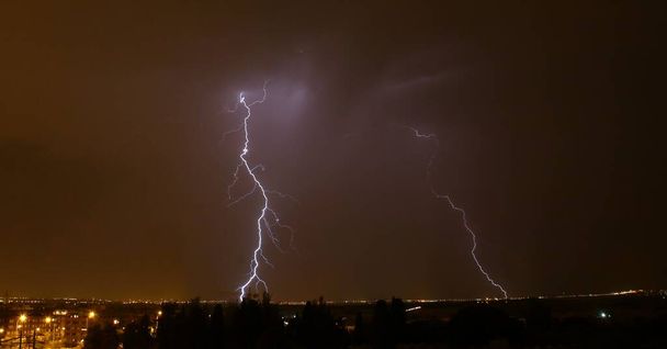 Bliksem in de skyline nacht van Madrid, Spanje. Zomerstorm in Madrid. - Foto, afbeelding