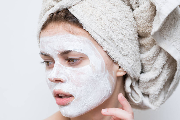 mulher bonita com toalha na cabeça máscara creme no rosto de perto - Foto, Imagem