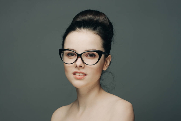 pretty woman naked shoulders gathered hair glasses emotions - Photo, Image