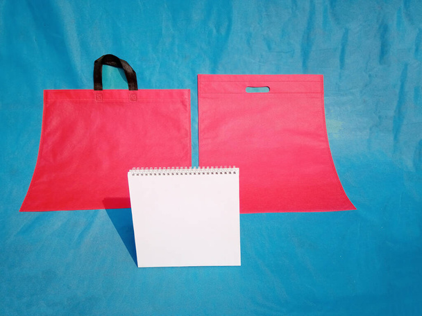 non-woven stoffen boodschappentassen op blauwe ondergrond. ECO Friendly Tote promotionele producten shopper tassen - Foto, afbeelding