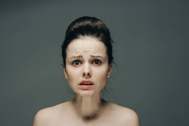 φοβισμένες γυναίκες πρόσωπο γυμνοί ώμοι hairstyle γκρι φόντο μοντέλο - Φωτογραφία, εικόνα