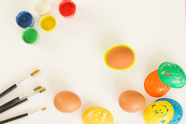 Stencil per dipingere uova di Pasqua, vernici e pennelli su sfondo bianco. Prepararsi per Pasqua. Sfondo festivo per il design. Ricevuto. Flatlay. - Foto, immagini