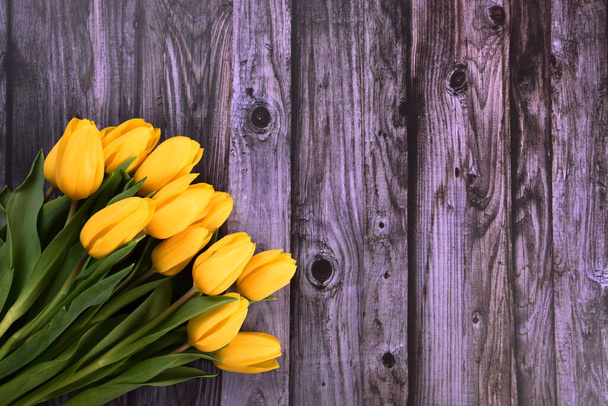 ramo de tulipanes amarillos en el fondo de una vieja tabla de madera gris, espacio para copiar. San Valentín, Día de la Mujer y el concepto del Día de la Madre. - Foto, Imagen