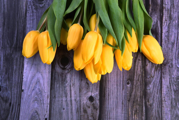 ramo de tulipanes amarillos en el fondo de una vieja tabla de madera gris, espacio para copiar. San Valentín, Día de la Mujer y el concepto del Día de la Madre. - Foto, Imagen