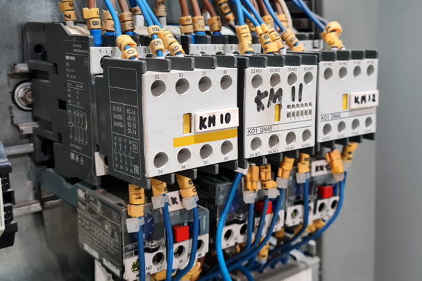 Close-up van magneetstarters op een rij in een elektrisch automatiseringskabinet industrieel systeem.  - Foto, afbeelding