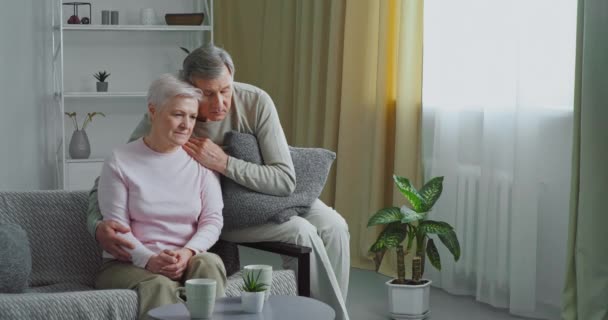 Gray-haired guilty man caring husband supports sad sick old wife soothes comforting upset frustrated woman with diagnosis hugs elderly lady apologizing after quarrel makes peace in difficult situation - Footage, Video