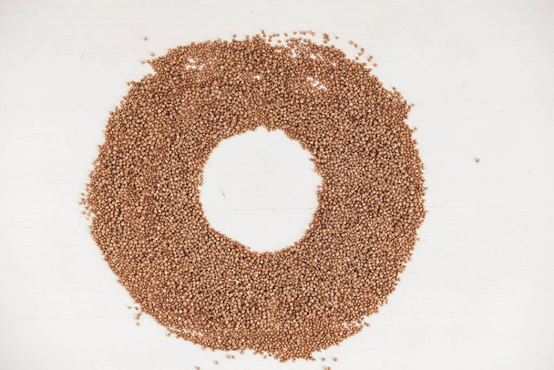 Buckwheat as a background texture in the form of a circle on a white background. Top view. Copy, empty space for text. - Photo, Image