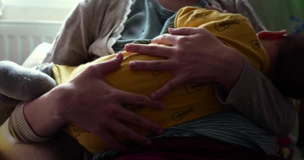 Matka kojit své novorozeně dítě na pohovce. Mléko z prsou matky je přirozený lék pro dítě. rodina, jídlo, dítě, pojetí jídla a rodičovství. zpomalený pohyb - Záběry, video