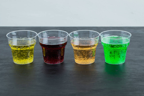 Jus multicolores dans des tasses jetables en plastique - Photo, image