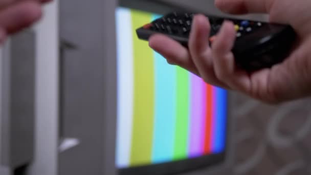 Γυναικείο χέρι που χρησιμοποιεί τηλεχειριστήριο TV προσπαθεί ένα διακόπτη SMPTE χρώμα μπαρ πρότυπο δοκιμής - Πλάνα, βίντεο