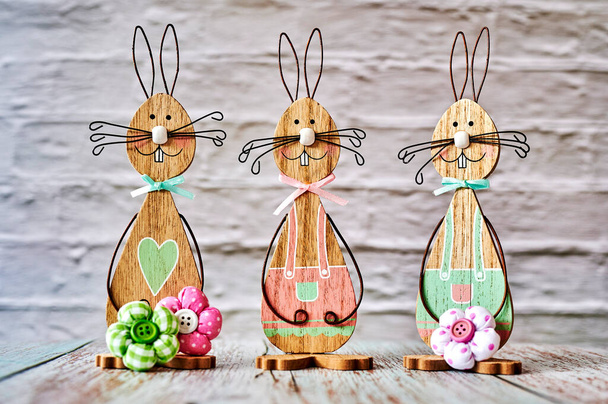 Tres conejitos de Pascua de madera con decoración. - Foto, imagen
