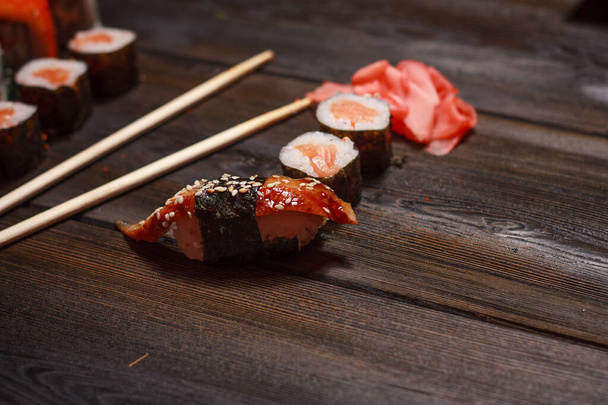 con bastoncini di sushi zenzero delicatezza pasto di fondo in legno - Foto, immagini
