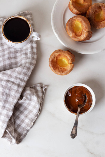 Yorkshire Puddings ze skondensowaną śmietaną i kawą. Domowej roboty tradycyjne puszyste złote Yorkshire Puddings. - Zdjęcie, obraz