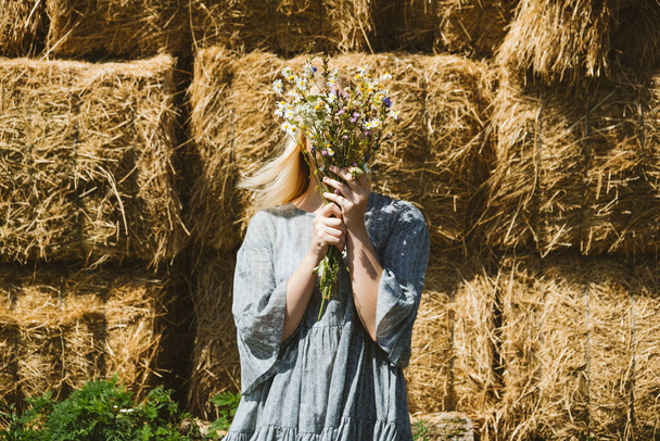 Cottagecore Farmcore Countrycore эстетика, свежий воздух, сельская местность, медленная жизнь, пастырская жизнь, пикники на открытом воздухе, носить бабушкину одежду. Молодая девушка в хлопковом платье с цветами прогулки по сельской ферме - Фото, изображение