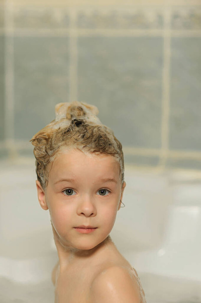 retrato de una niña en un baño con cabello enjabonado - Foto, Imagen