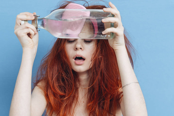 женщина с красными волосами бутылку алкоголя похмелья сон маска синий фон - Фото, изображение