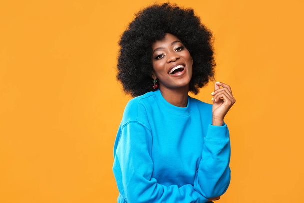 Fashionable black woman on orange background. - Photo, Image