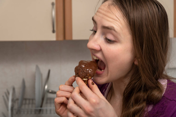 A rapariga come um bolo de chocolate gananciosamente. Fim da dieta. - Foto, Imagem