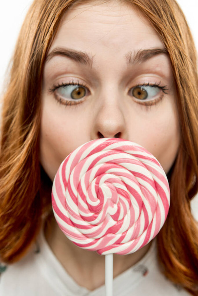 woman with open mouth holds lollipop near face Sweets joy  - Fotografie, Obrázek