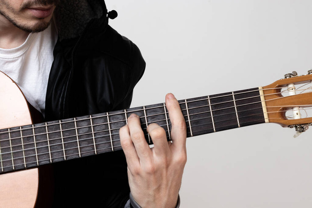 junger Mann spielt Gitarre auf weißem Hintergrund - Foto, Bild