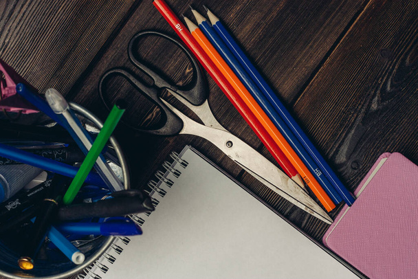 блокноты цветные карандаши ножницы офис вид сверху - Фото, изображение