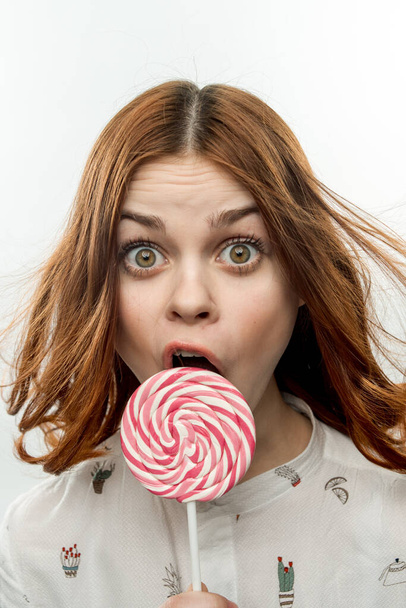 cheerful pretty woman licking lollipop dessert emotions close-up - Foto, Imagem
