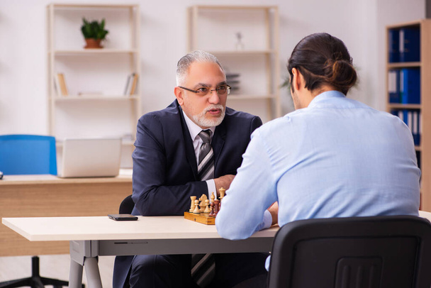 2人のビジネスマンがオフィスでチェスをする - 写真・画像