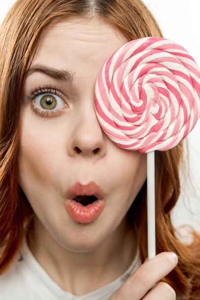 femme émotionnelle avec sucette ronde près du visage bonbons gros plan - Photo, image