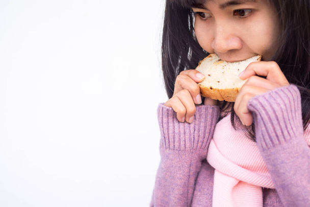 Aziatische vrouw met guernsey eten rozijnenbrood hongerig en heerlijk in de winter. Ontbijt- of snackfoodconcept. - Foto, afbeelding