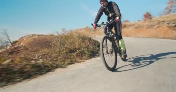 Kokopäiväinen pyöräilijä ratsastus hänen pyörä tiellä vuoren kukkuloilla - Materiaali, video