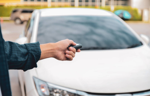 Autó távirányító intelligens billentyűvel, Kézben tartva okos gombot, hogy zárja ajtók fehér autó - Fotó, kép
