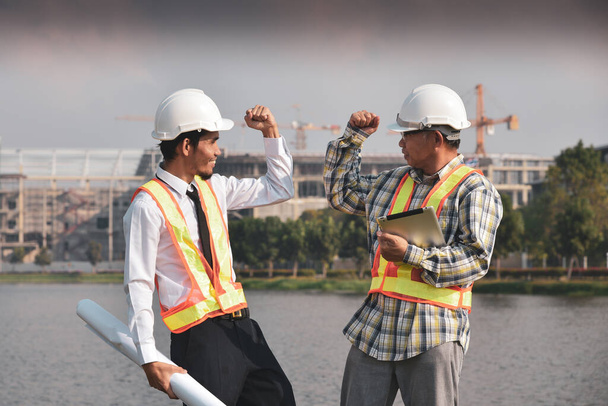 Dos ingenieros de construcción masculinos asiáticos disfrutaron del éxito del proyecto de construcción. - Foto, Imagen
