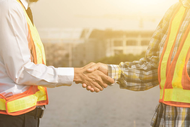 Ingegnere edile business handshake contro edificio costruzione sfondo - Foto, immagini