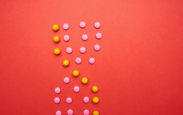 píldoras multicolores en rojo medicina de fondo salud - Foto, imagen