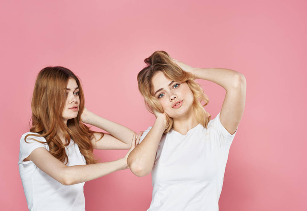 duas jovens namoradas em t-shirts brancas corte vista rosa fundo - Foto, Imagem