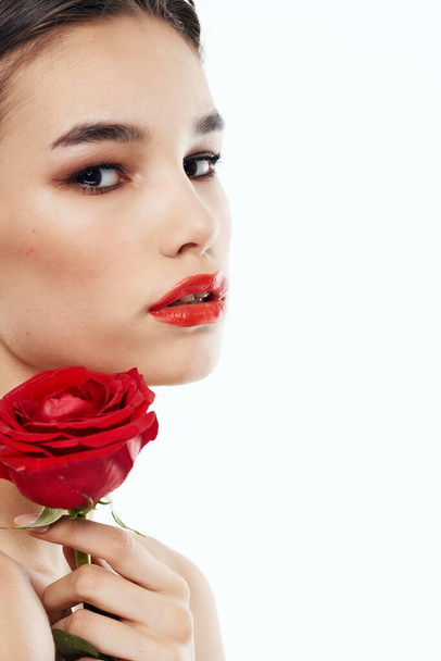 Oldalra néző romantikus nő piros virág közel arc - Fotó, kép