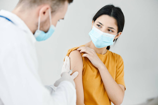 una enfermera le da una inyección a una epidemia de infección de la vacuna del hombro de las mujeres - Foto, Imagen