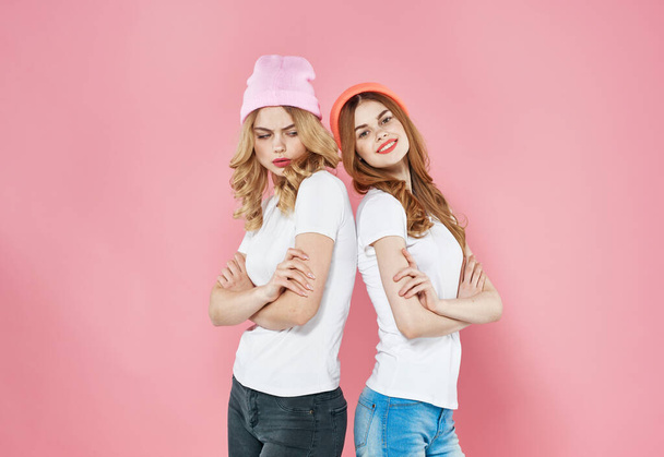 二人の可愛いです女性身に着けているピンクの帽子ファッショナブルな服スタジオクロップドビューのモデル - 写真・画像