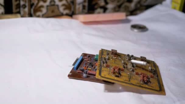 Mannelijke hand gooit op tafel oude gedrukte schakelborden, microcircuits, radio-onderdelen - Video